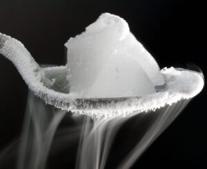 Dry ice, solid carbon dioxide on a spoon undergoing sublimation