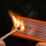 Friciton between a match and a matchbox, causing ignition of the match